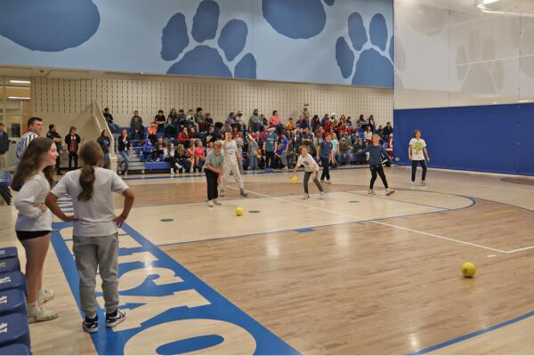 Students pictured playing dodgeball in the middle school gym.