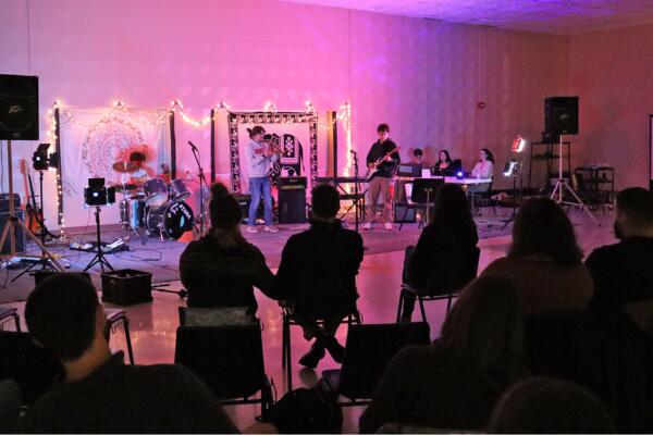 A photograph of a large audience attending the January Coffee House in the Oyster River High School Multipurpose room.