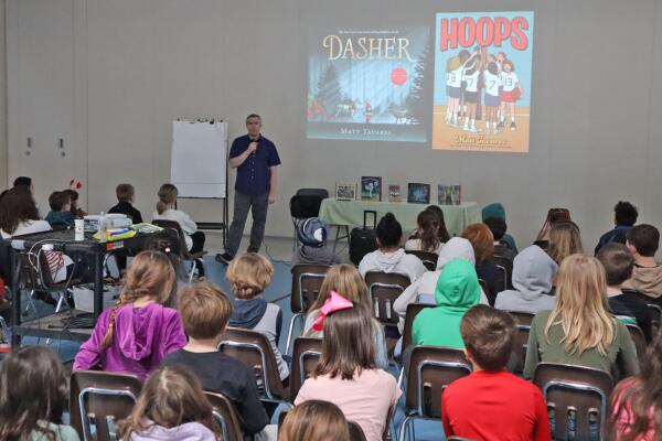 Matt Tavares, pictured at Moharimet School in front of a large audience of 3rd and 4th grade students.