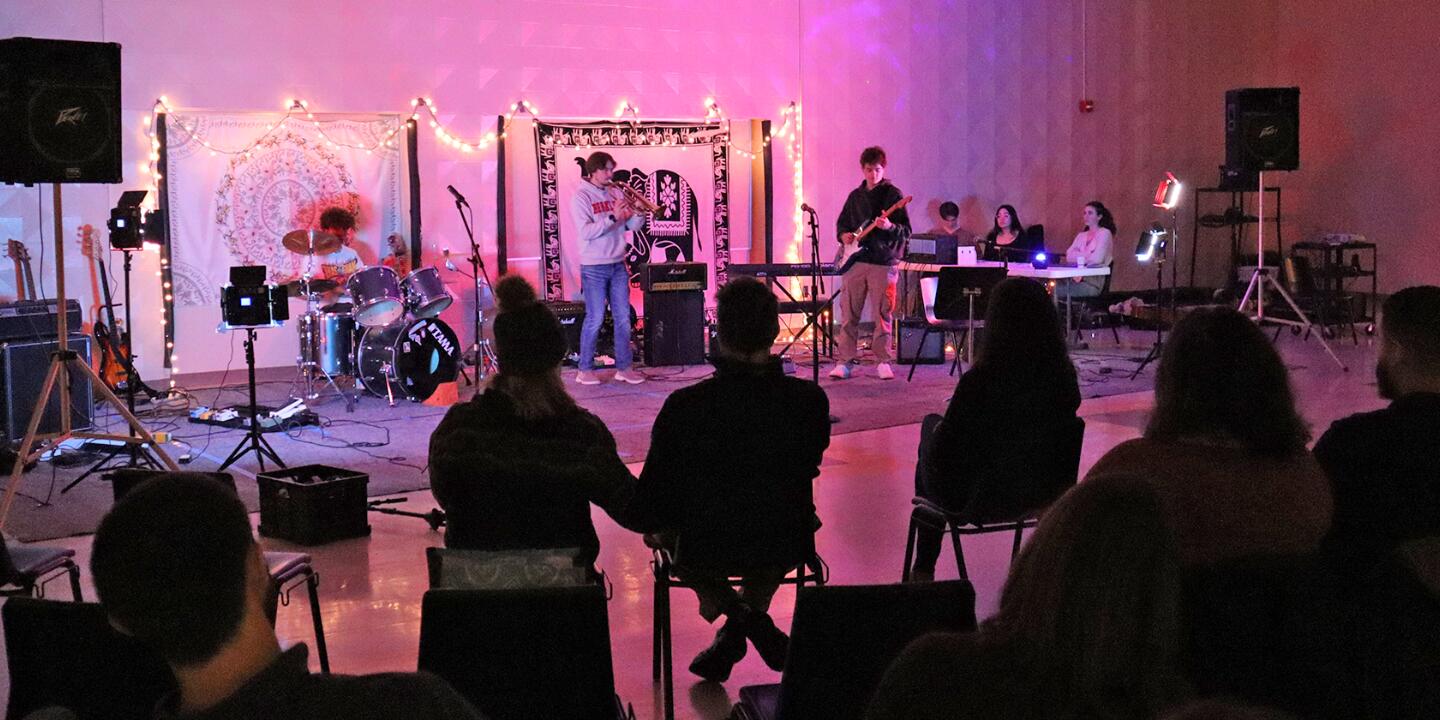 High School students playing live music in front of an audience in the multipurpose room at the oyster river high school