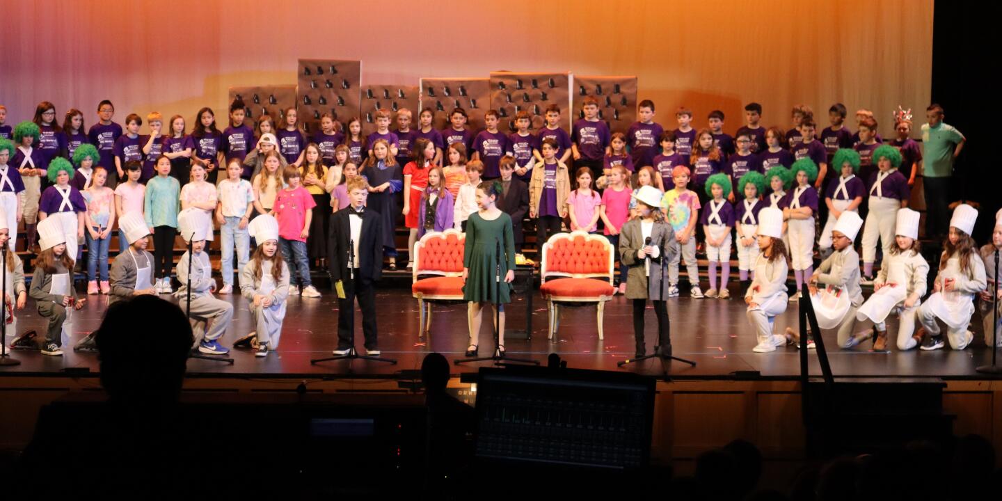 Children on stage performing Willy Wonka Jr.